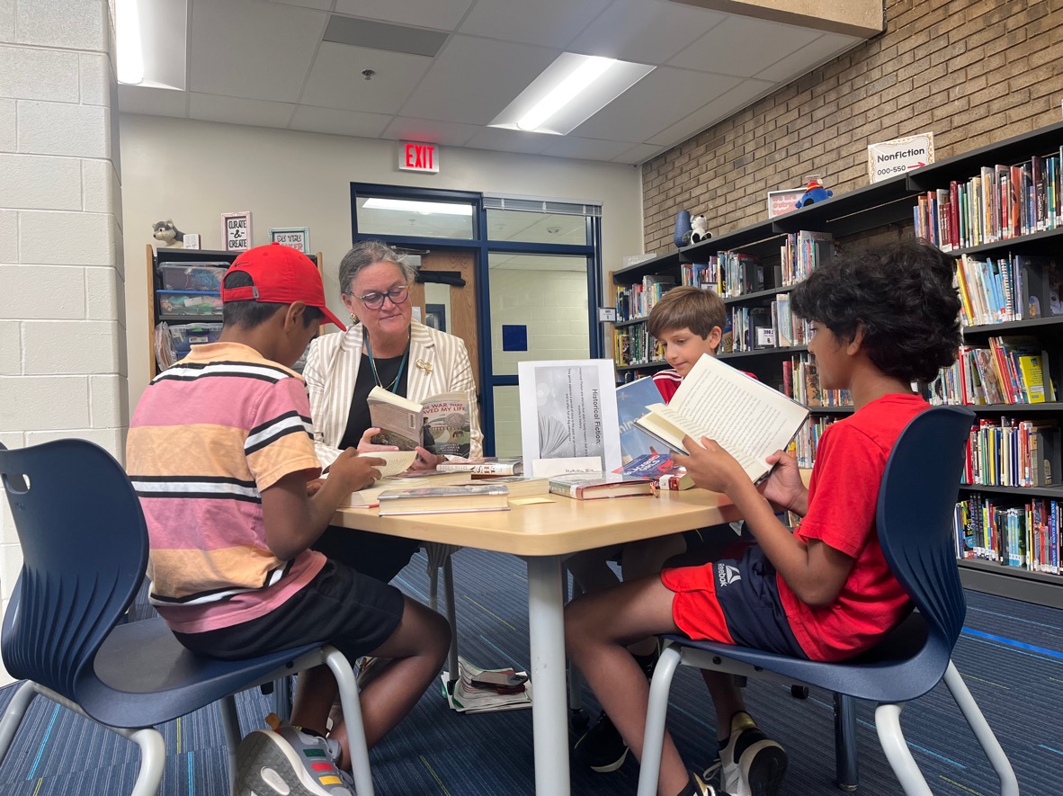 Dr. Reid "book sampling" with students at the Oak Hill ES library