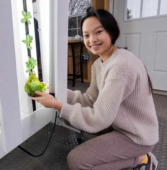 student holding plant grown in water