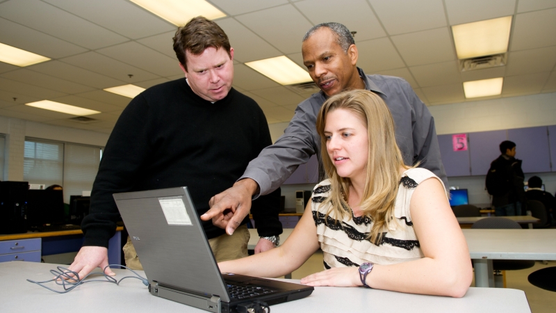 photo of three adults collaborating on a project