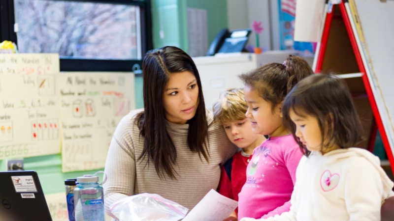 teacher working with young students