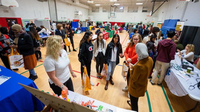 students at a fair in a high school gymnasium