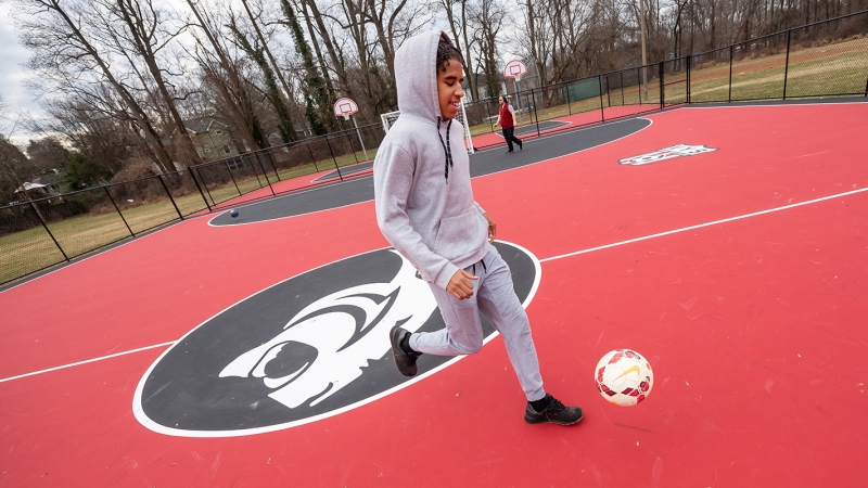 A student at Cedar Lane School practices his soccer moves on a new futsal court 