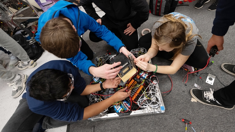 Students work on a robot. 