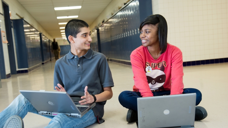 photo of students on computers in a school hallway