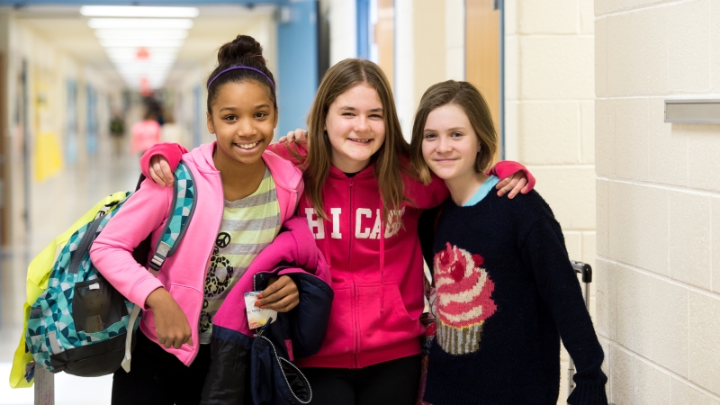 image of three students standing in a hallway posing for a picture