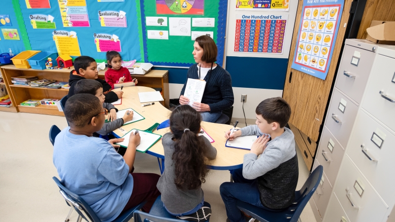 Teacher with students around a table in a classroom