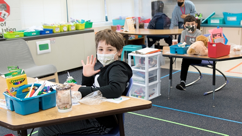 Student holding up his hand to show five fingers