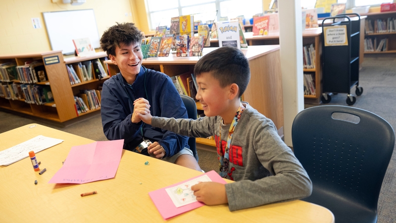 two students high-fiving