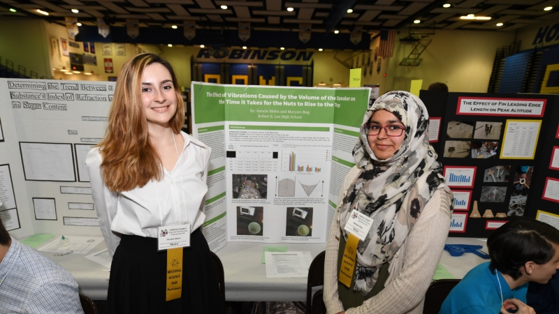 two students standing in front of their science fair project