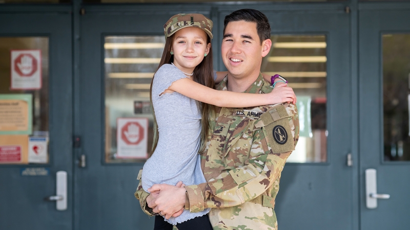 Dad in military uniform with daughter