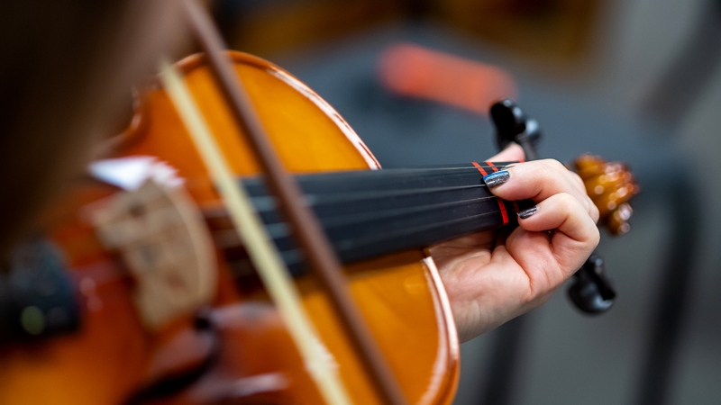 Close up of a student hand playing a violin