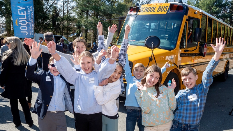 Students smiling after arriving to school by bus.