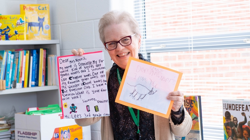 Stratford Landing Elementary School reading specialist Jill Norris holds up letters that students have written to her