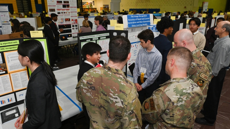 a student explaining their project to science fair visitors