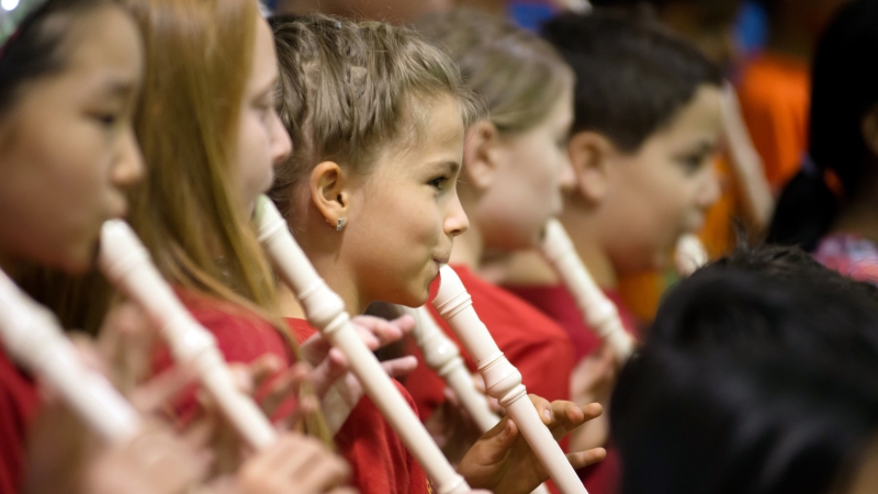 Elementary school students playing recorders.