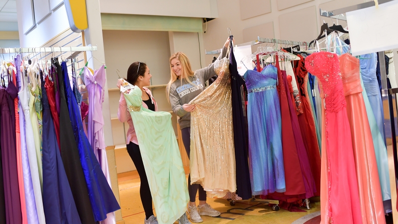 Students pick out prom dresses. 