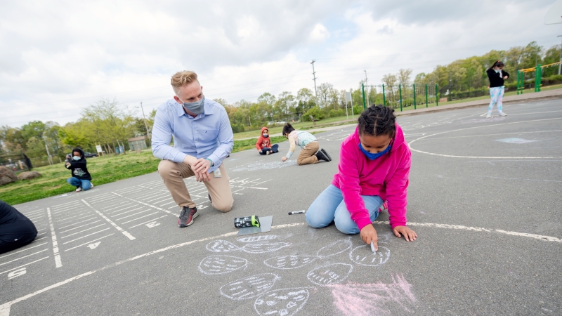 Student and teacher on school blacktop.