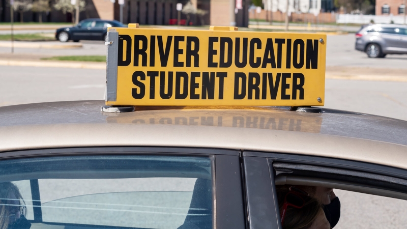 a yellow sign on top of  a car that says driver education student driver