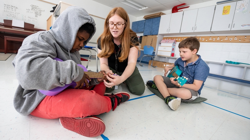 Students learn to play the ukulele in music therapy class. 