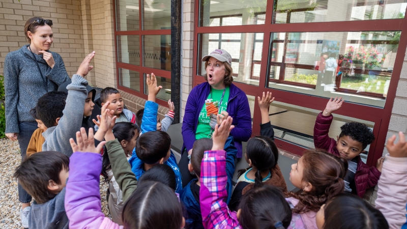 Students getting seeds for planting from an adult. 