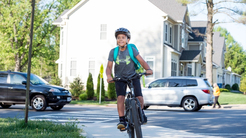 Male student riding a bike to school