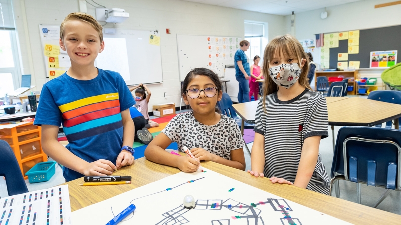 Three students smiling.