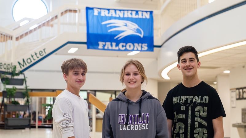 Three students smiling.