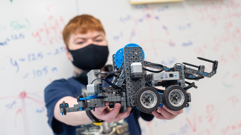 A student holds a robot