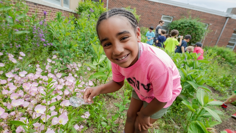 Students at Navy Elementary School explore a pollinator garden in their outdoor learning lab. 