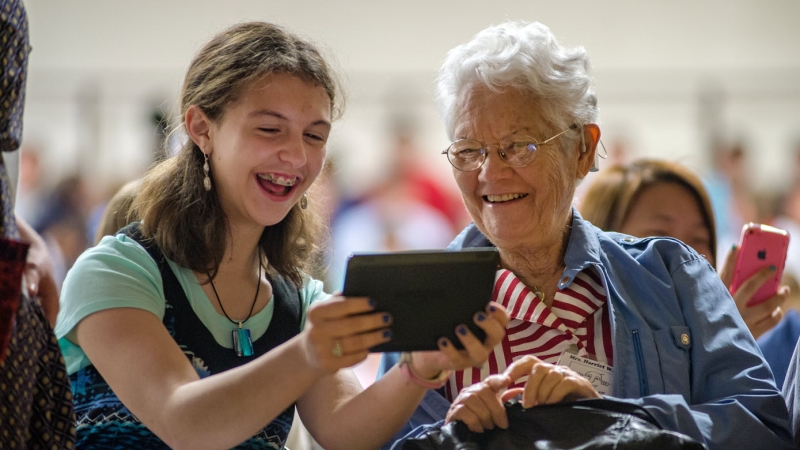 Student looking at mobile device with an adult