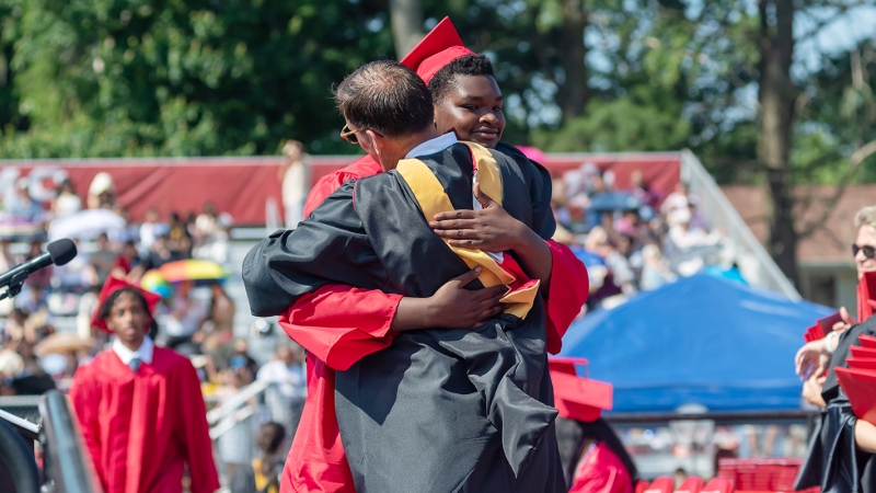 A graduate hugs an administrator