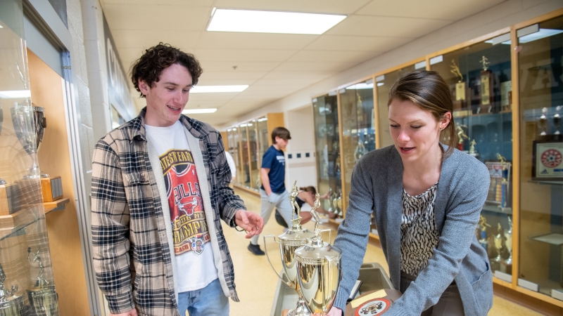 Alexa Pugnetti and a student arrange trophies