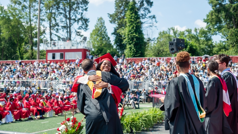 A student hugs Shawn DeRose. 