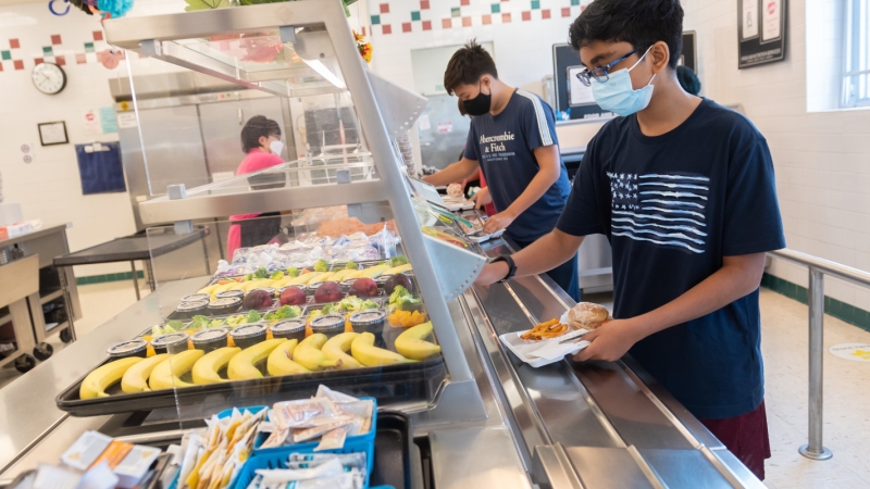 A student selects food for their lunch in a school cafeteria. 