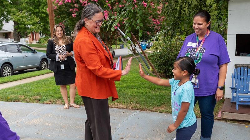 Superintendent Reid meeting a young a student at their home.