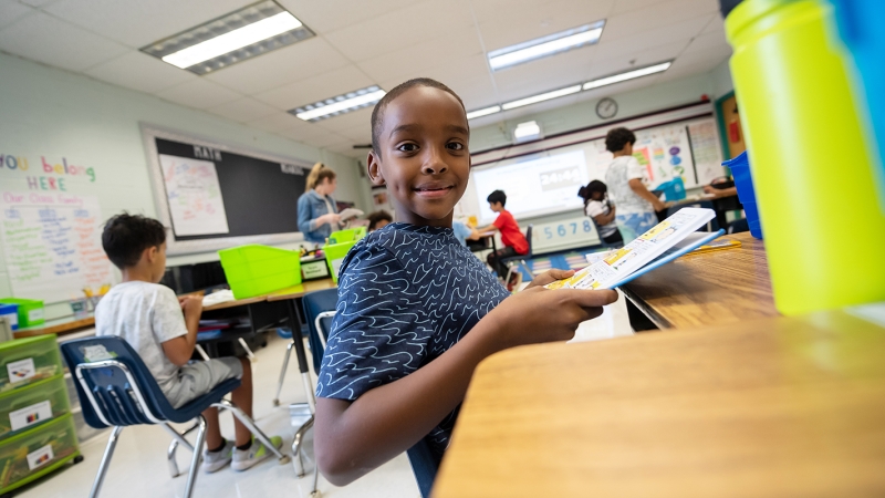 male student sitting at a desk looking at the camera