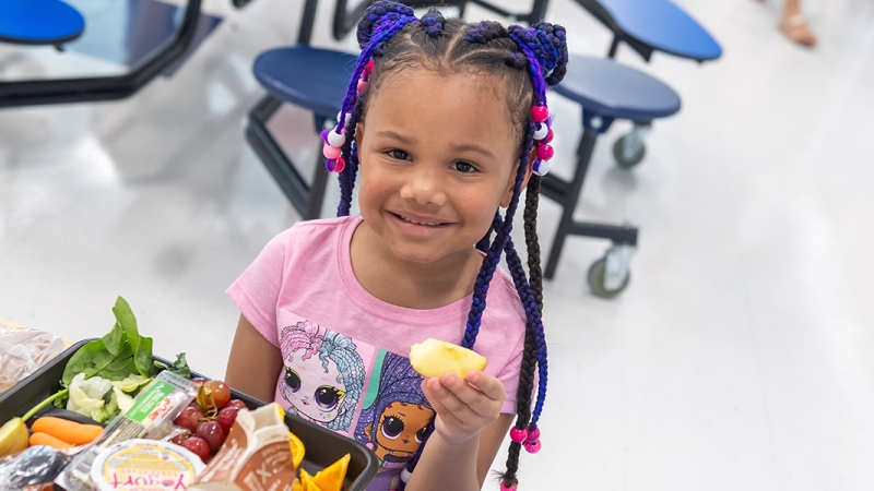 A girl eats a school lunch