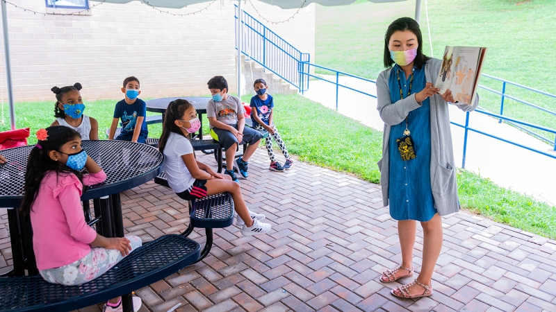 Teacher and students in an outdoor classroom. 