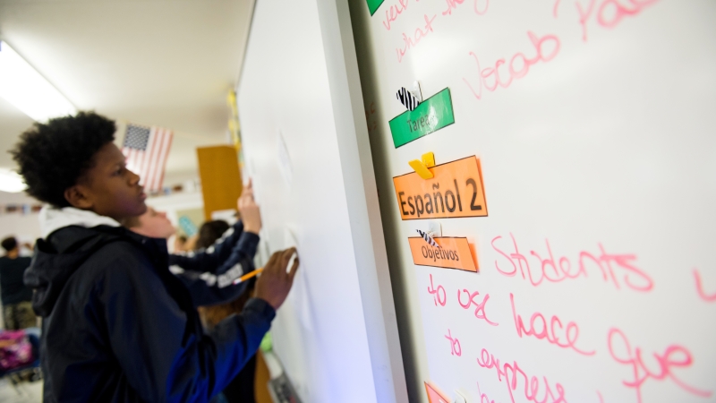 student working on language studies on a white board.