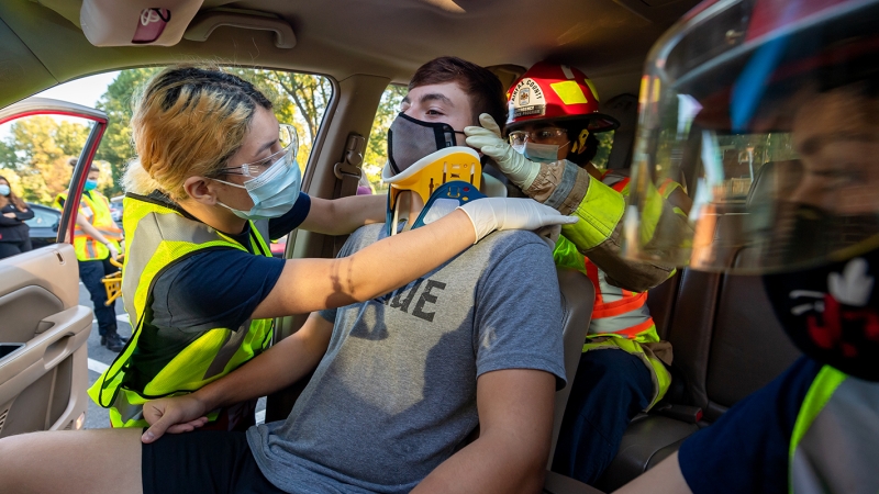 Emergency medical technician students practicing removing a student from a car. 