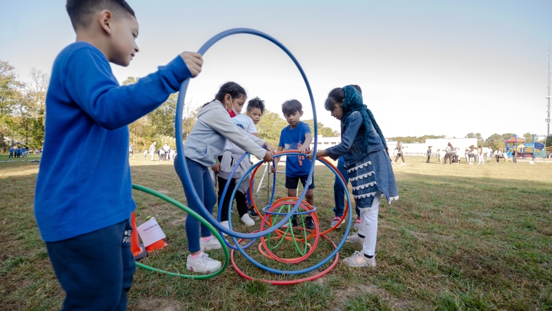 Students play with hula hoops outdoors. 