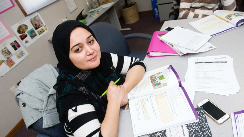 photo of a student at a table looking at the camera