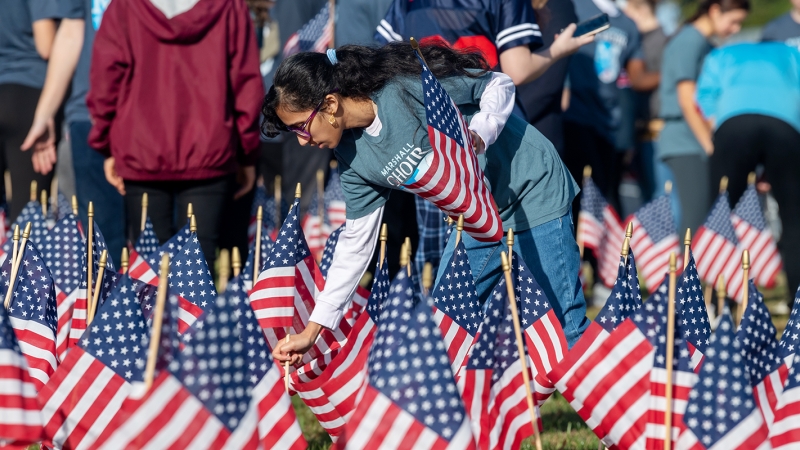 A student plants American flags