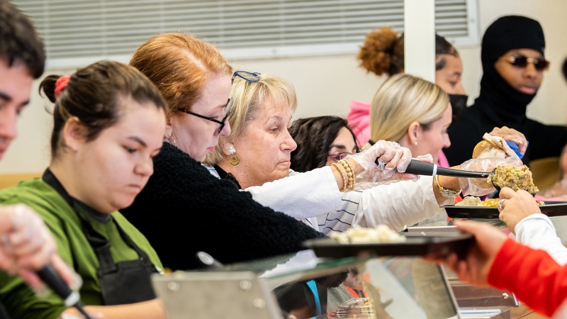 Staff serve students a thanksgiving meal. 