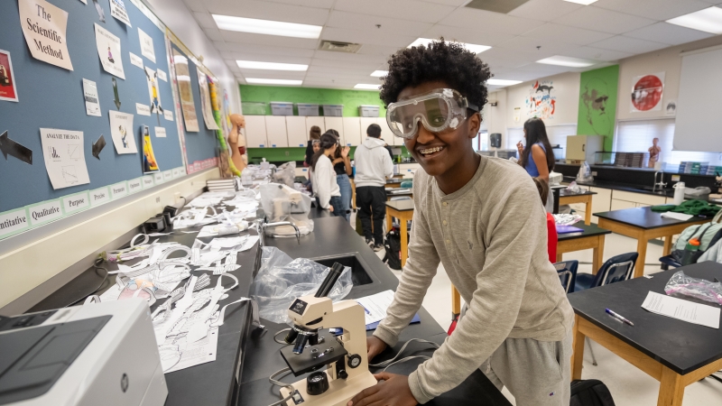 A student uses a microscope in biology class at McLean High School.