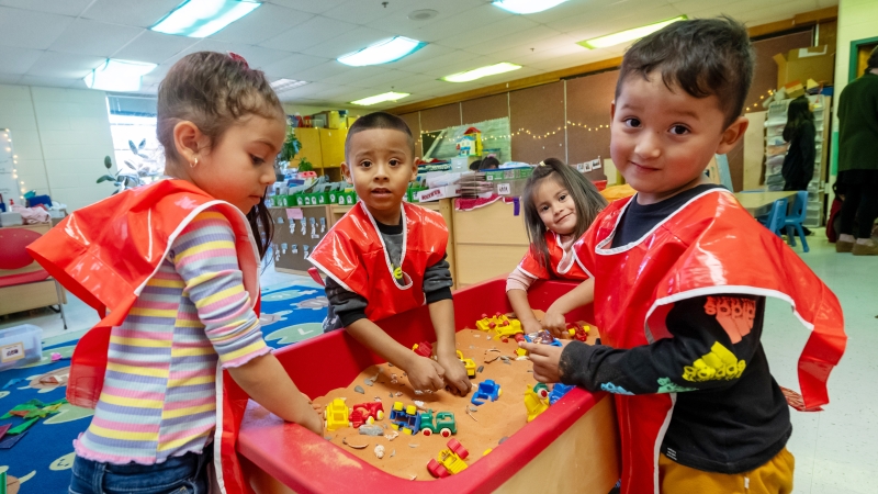 Preschoolers play in sand. 