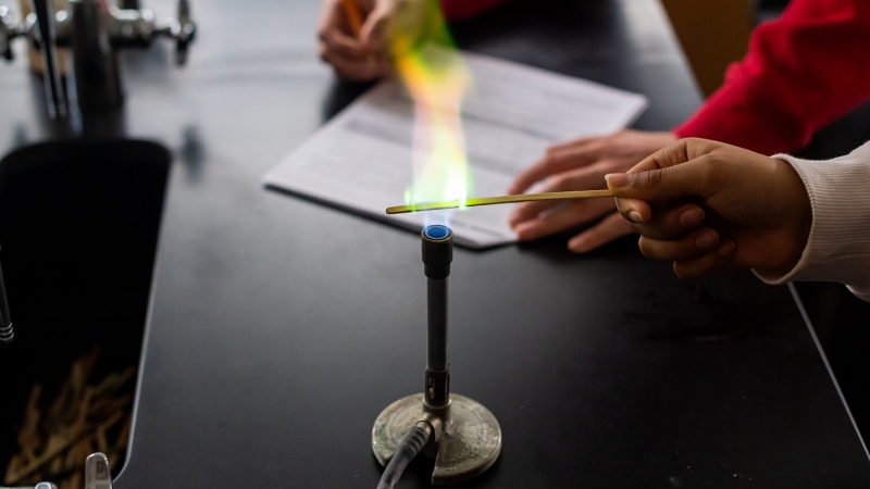 A student experiments with a bunson burner