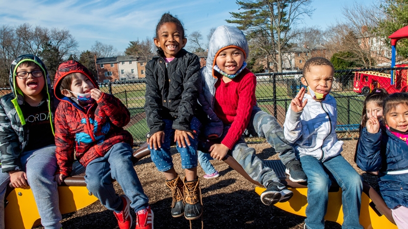 Students play outdoors in winter wear. 