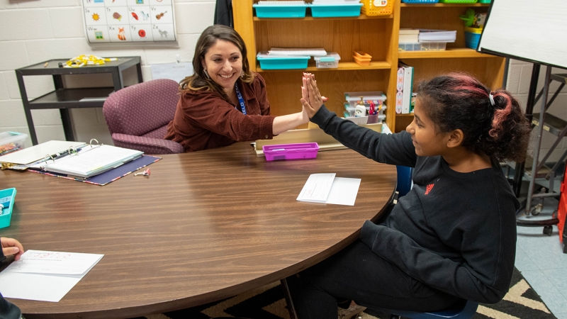 Teacher high fives a student