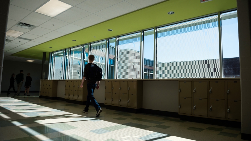 Boy walking down a school hallway